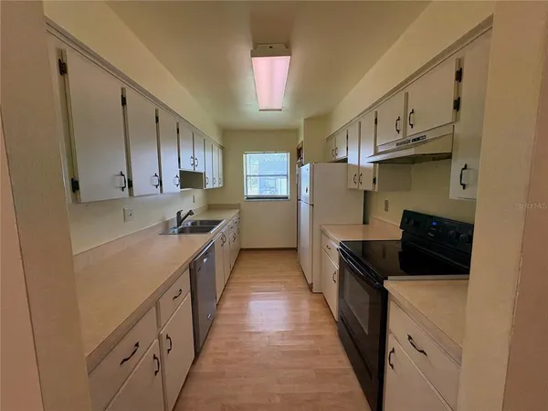 a kitchen with stainless steel appliances granite countertop a stove a sink and a refrigerator