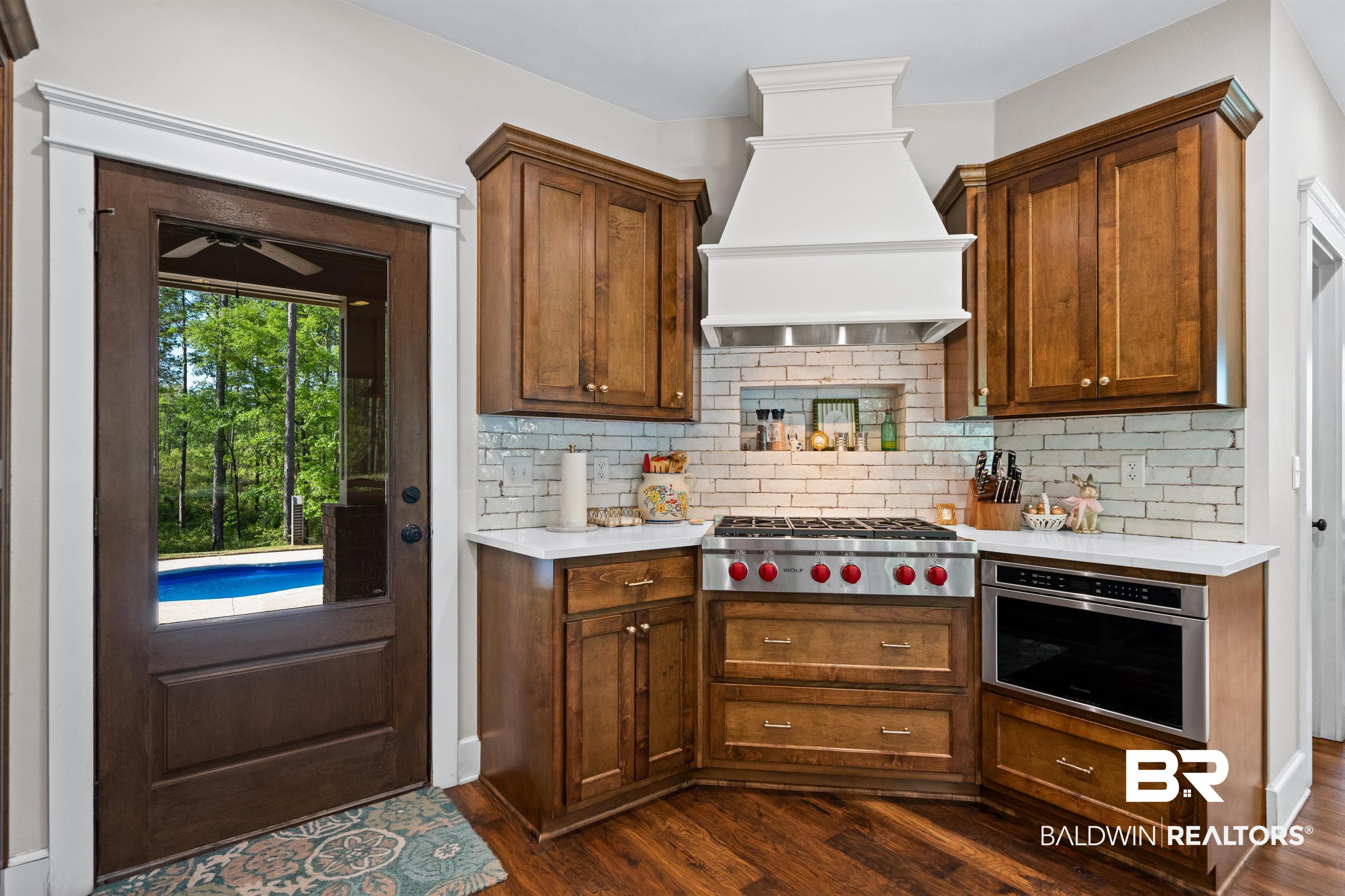 47252 Emmons Road Bay Minette, AL 36507 - Photo 15 of 50 Kitchen with stainless steel appliances, dark wood-style flooring, decorative backsplash, and a ceiling fan