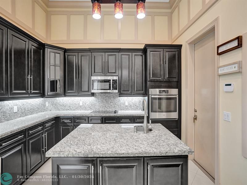1965 Park Place Boca Raton, FL 33486 - Photo 12 of 30 a kitchen with kitchen island granite countertop a sink and stove
