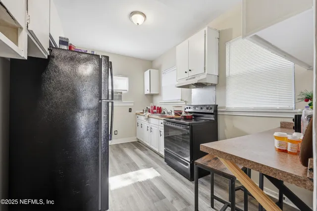a kitchen with a refrigerator and a stove top oven
