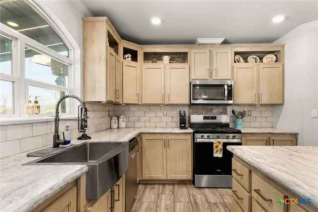 a large kitchen with kitchen island a sink a counter space and stainless steel appliances