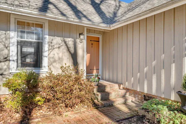 a view of a hallway with wooden floor and windows