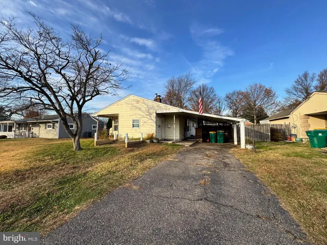 a front view of a house with a yard and trees