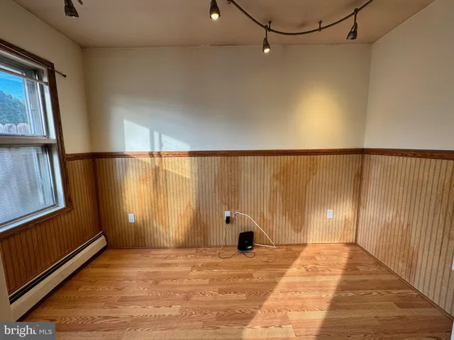 a view of a hallway with wooden floor and door