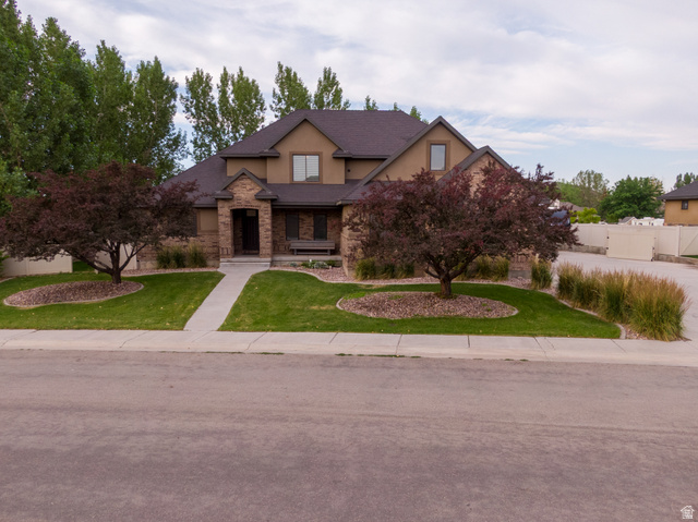 Two-story property featuring a stucco and brick exterior with a dark shingle roof