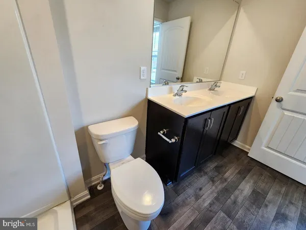 a bathroom with a sink vanity mirror and toilet