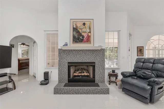 a bedroom with a bed a chair and a large window