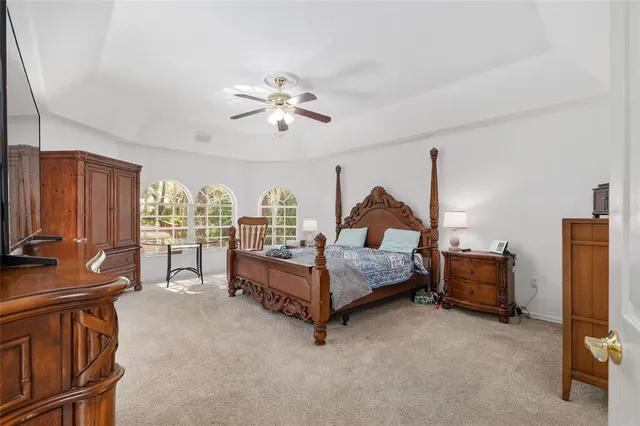 a backyard of a house with large trees and outdoor seating