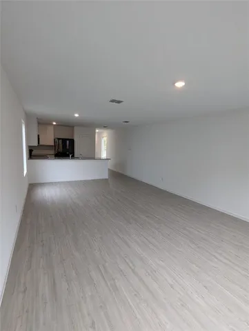 a view of a room with wooden floor and window