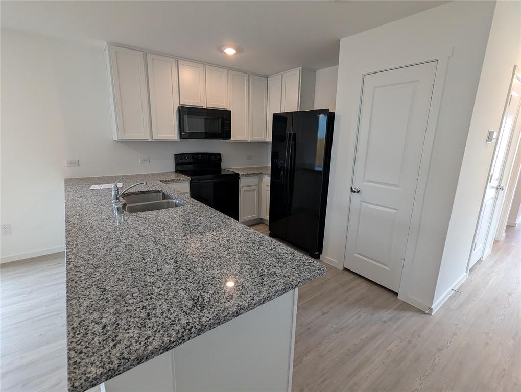 904 Wood Stork Way Princeton, TX 75407 - Photo 13 of 40 a kitchen with granite countertop a refrigerator and a sink