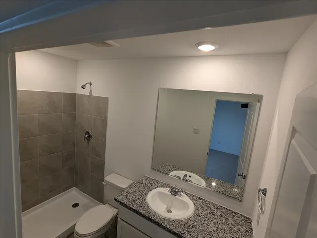 a bathroom with a sink and mirror with toilet