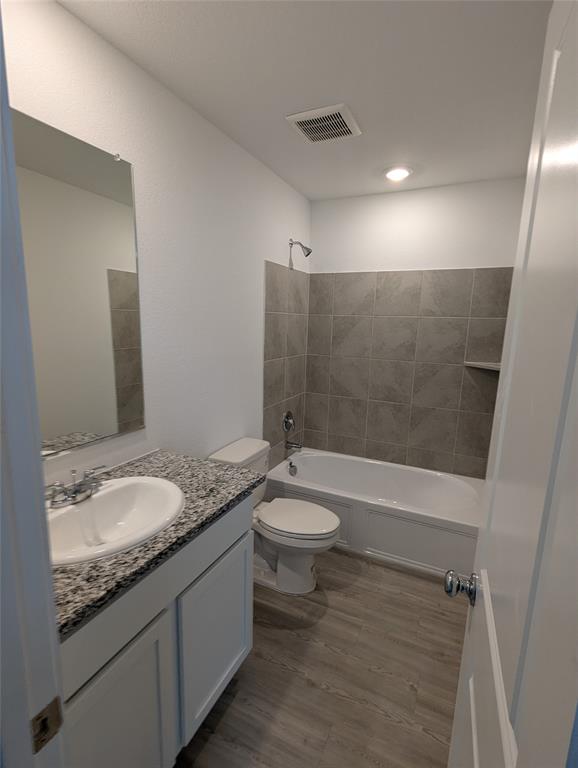 904 Wood Stork Way Princeton, TX 75407 - Photo 26 of 40 a bathroom with a granite countertop sink a toilet a mirror and shower