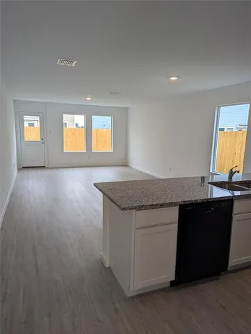 a kitchen with granite countertop a sink and a wooden floor