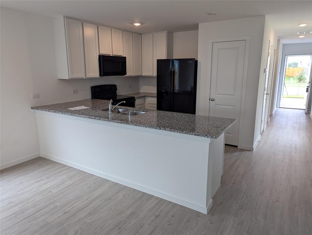 904 Wood Stork Way Princeton, TX 75407 - Photo 9 of 40 a kitchen with stainless steel appliances a refrigerator and a stove top oven