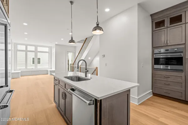 a kitchen that has a sink a stove and a wooden floor