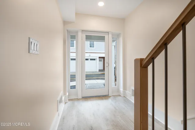 a view of a hallway with wooden floor and entryway