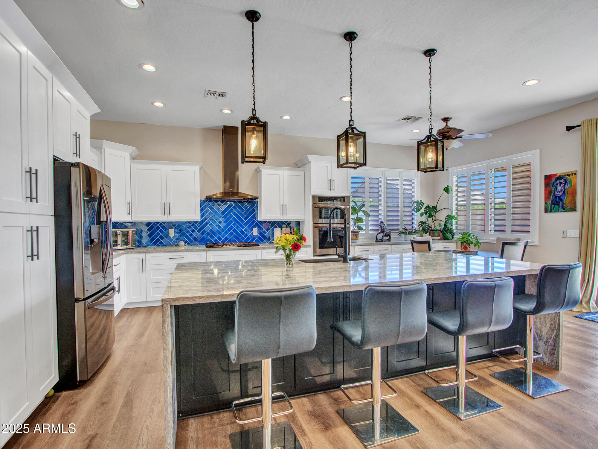 6919 West Rowel Road Peoria, AZ 85383 - Photo 17 of 74 a kitchen with stainless steel appliances kitchen island granite countertop a sink a stove a refrigerator and chairs