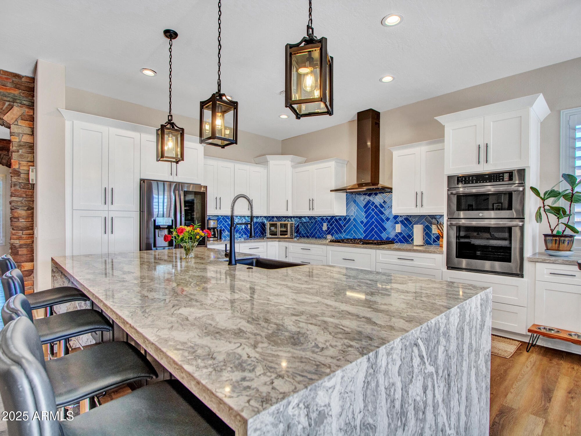 6919 West Rowel Road Peoria, AZ 85383 - Photo 23 of 74 a large kitchen with stainless steel appliances granite countertop a stove and a wooden floors