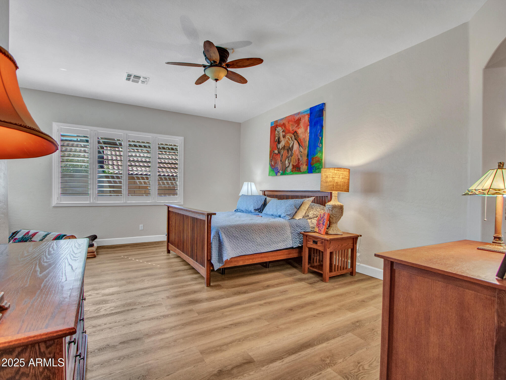 6919 West Rowel Road Peoria, AZ 85383 - Photo 45 of 74 a bedroom with a bed and wooden floor