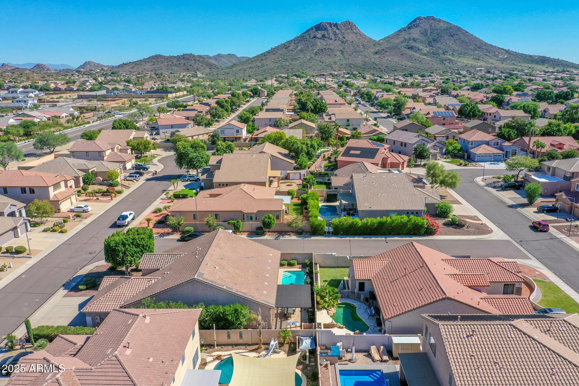 6919 West Rowel Road Peoria, AZ 85383 - Photo 66 of 74 an aerial view of a city with lots of residential buildings and mountain view in back
