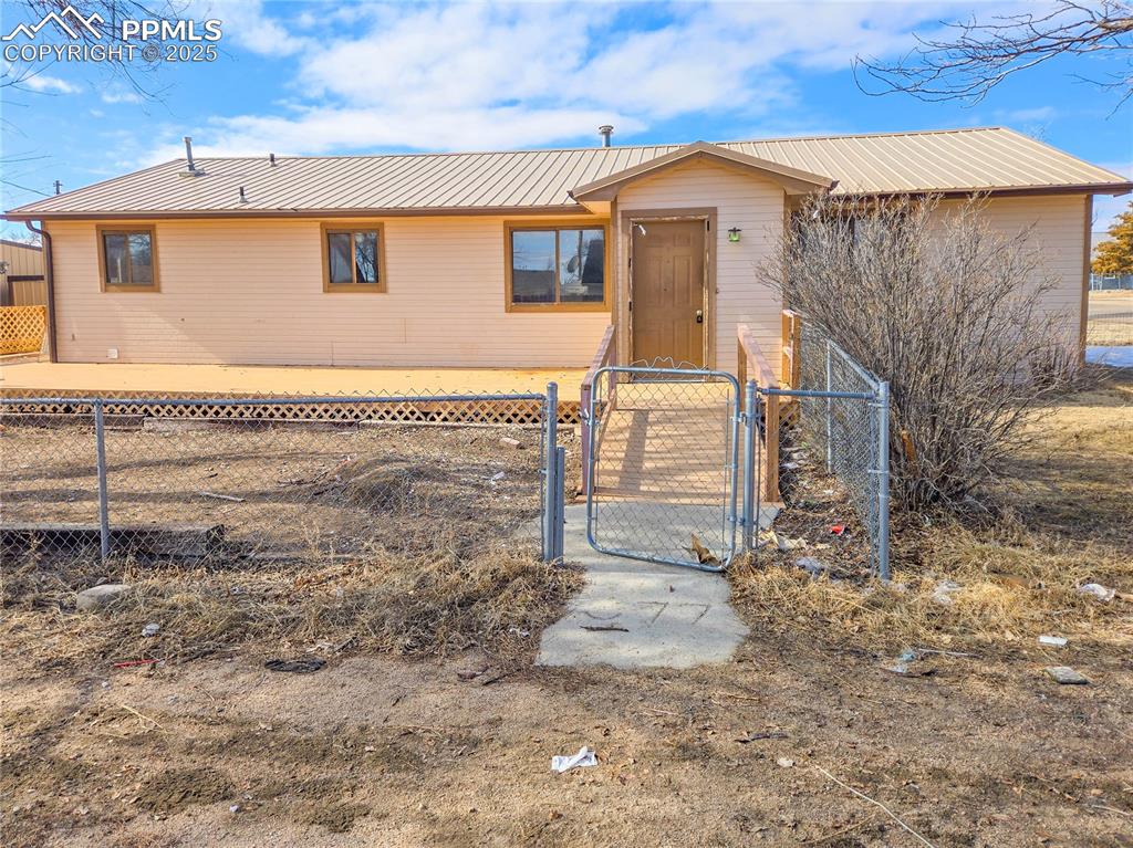 722 6th Street Hugo, CO 80821 - Photo 2 of 35 Ranch-style home featuring fence, metal roof, and a gate