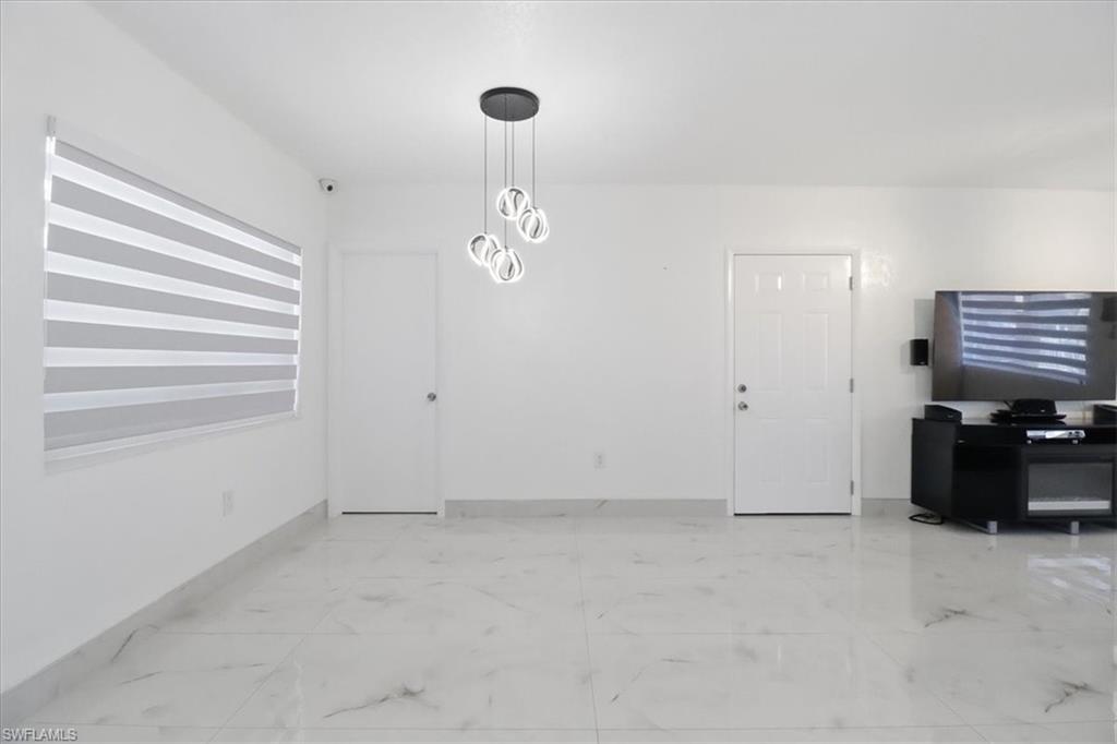 6800 Northwest 28th Avenue Miami, FL 33147 - Photo 11 of 40 Dining space featuring light marble finish flooring and a chandelier