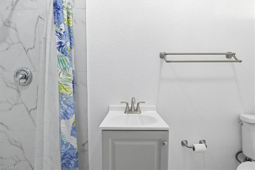 6800 Northwest 28th Avenue Miami, FL 33147 - Photo 21 of 40 Bathroom featuring a marble finish shower, vanity, and a textured wall