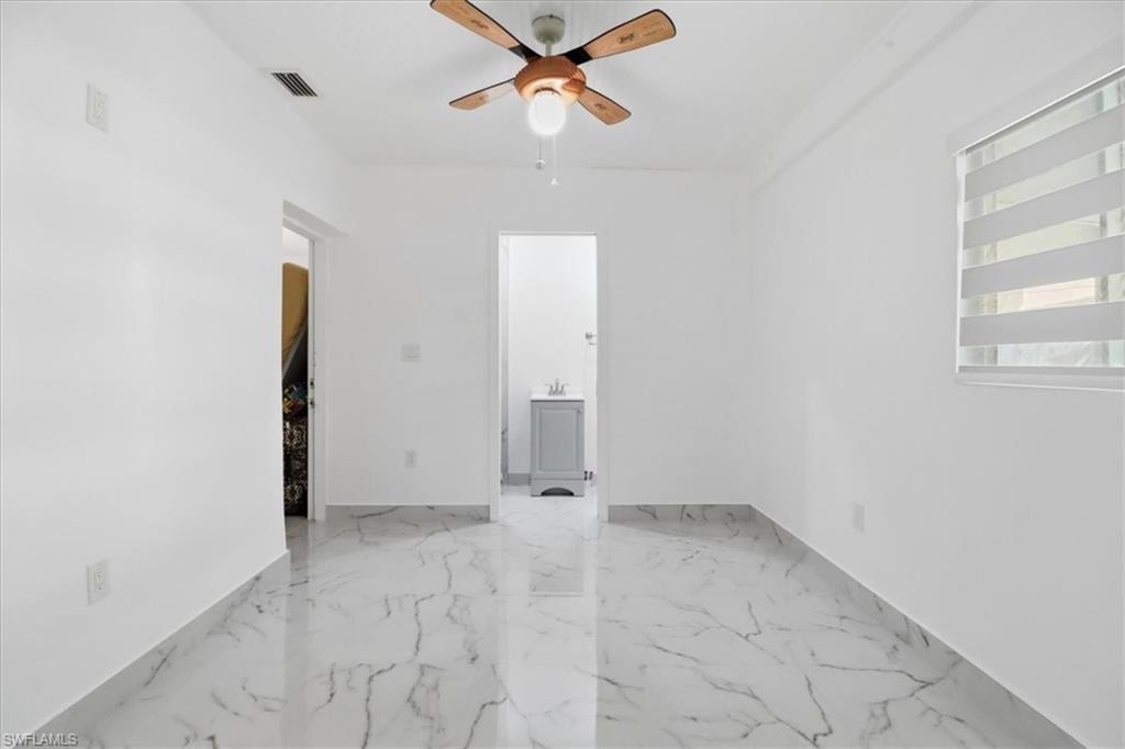 6800 Northwest 28th Avenue Miami, FL 33147 - Photo 25 of 40 Spare room featuring ceiling fan and light marble finish floors