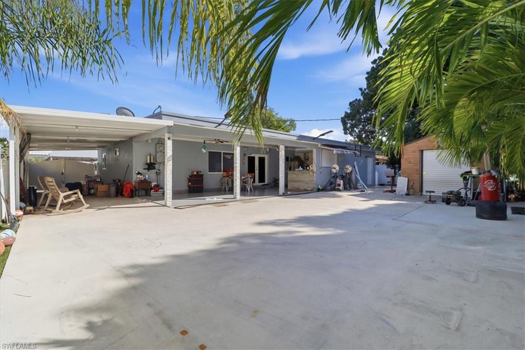 6800 Northwest 28th Avenue Miami, FL 33147 - Photo 34 of 40 Rear view of property featuring a patio, an attached carport, and driveway