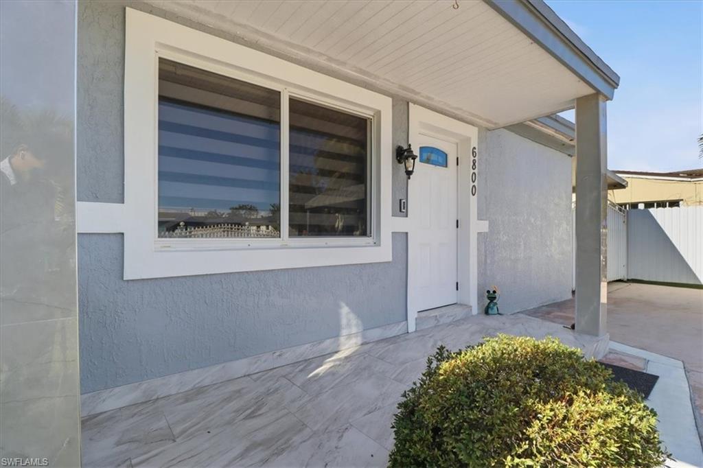 6800 Northwest 28th Avenue Miami, FL 33147 - Photo 7 of 40 View of exterior entry featuring stucco siding and covered porch