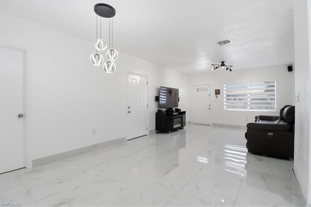 6800 Northwest 28th Avenue Miami, FL 33147 - Photo 9 of 40 Living area featuring a chandelier and light marble finish floors