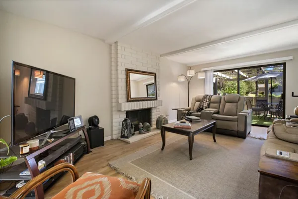 a living room with furniture a floor to ceiling window and a flat screen tv