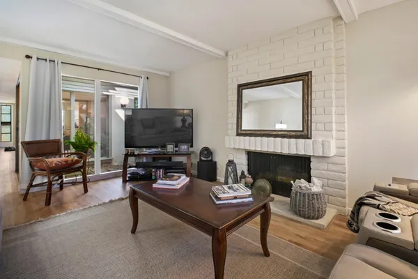 a kitchen with granite countertop a refrigerator a sink a stove and white cabinets with wooden floor