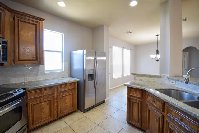 a kitchen with stainless steel appliances granite countertop a sink and a refrigerator