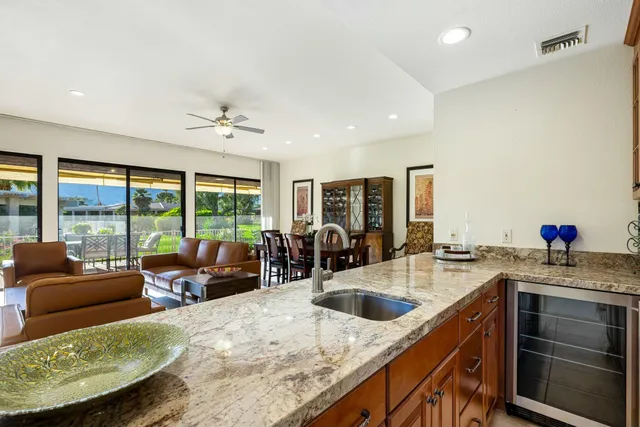 a kitchen with stainless steel appliances granite countertop a sink a stove and a refrigerator
