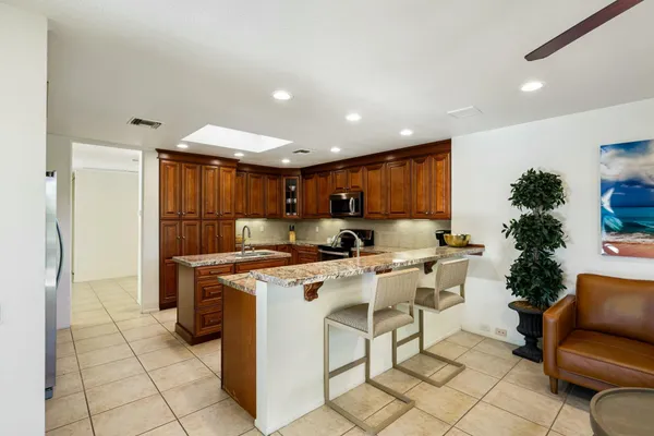 a view of kitchen with furniture a refrigerator and a wooden floor