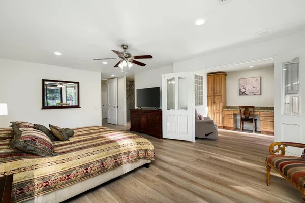 a spacious bedroom with a bed a couch and a flat screen tv