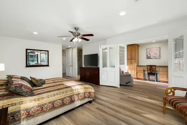 a spacious bedroom with a bed a couch and a flat screen tv