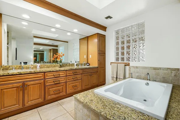 a bathroom with a tub sink and mirror
