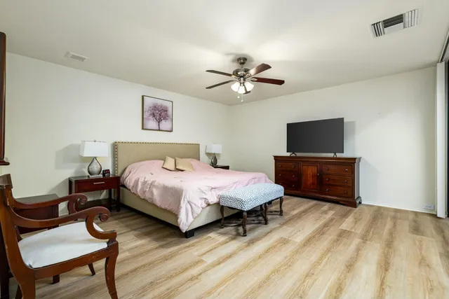 a spacious bedroom with a bed and a tv on table