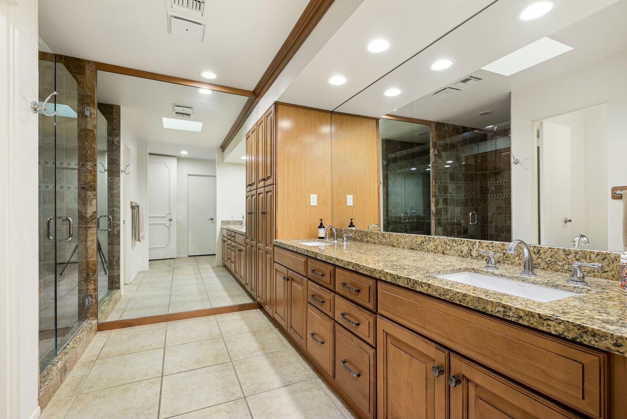 6 Stanford Drive Rancho Mirage, CA 92270 - Photo 27 of 39 a bathroom with a granite countertop sink mirror and shower