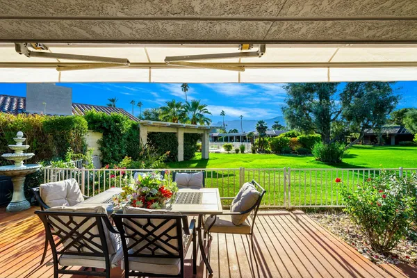 a view of a chairs and table in patio with a yard