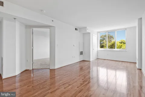 an empty room with wooden floor and window