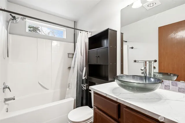 a bathroom with a granite countertop sink toilet and shower