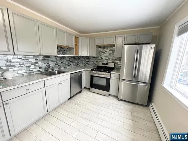 a kitchen with white cabinets and stainless steel appliances