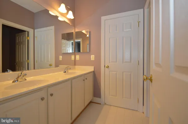 a bathroom with a double vanity sink and a mirror