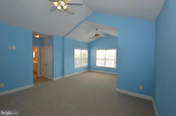 en empty room with windows and chandelier fan