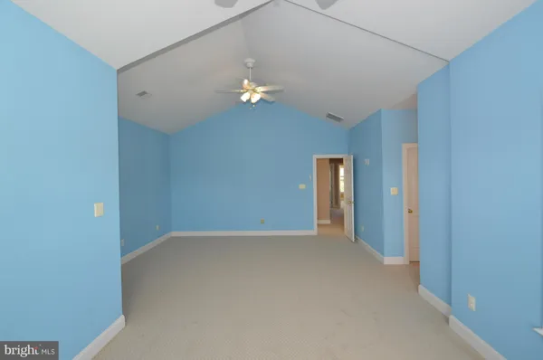 a view of an empty room with a chandelier fan