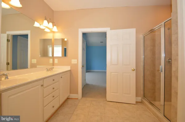 a spacious bathroom with a double vanity sink and a mirror