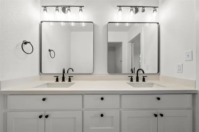 a bathroom with double vanity sinks and a mirror